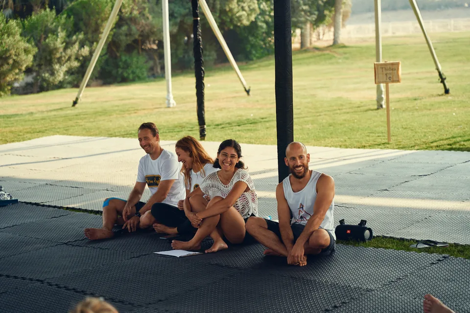 The EAC organizers sitting together and laughing on the training mats